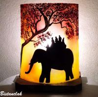 lampe décorative rouge et jaune au dessin d une ballade a dos d elephant